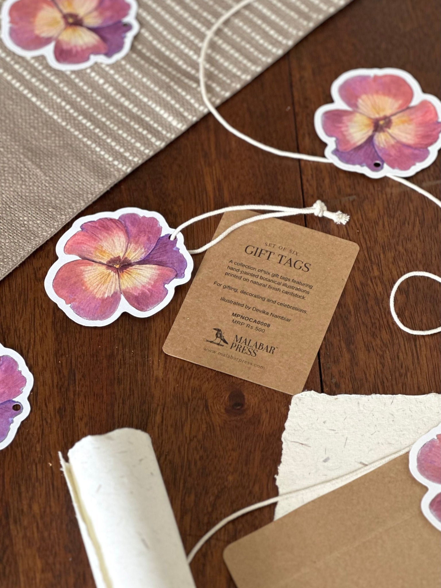 Floral gift tags with a brown paper tag on a wooden surface